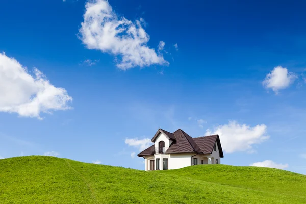 Nieuw huis op groene veld — Stockfoto