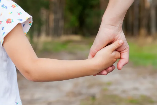 Mother holding a hand of his doughter outdoors — Stock Photo, Image