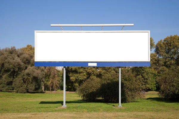 Yeşil çimlerin üzerindeki boş reklam panosu — Stok fotoğraf