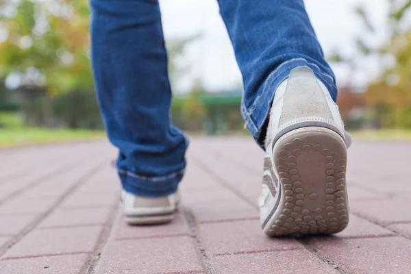 Walking in sport shoes on pavement — Stock Photo, Image
