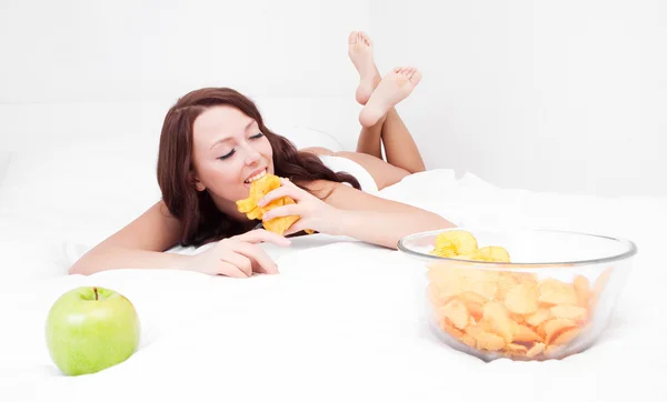 Kvinna med äpple och chips — Stockfoto