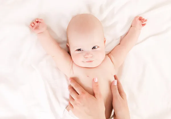 Mother massaging baby Stock Photo