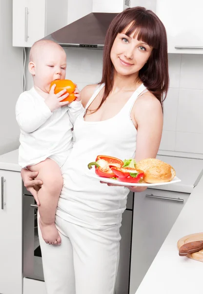 Woman with baby cooking — Stock Photo, Image