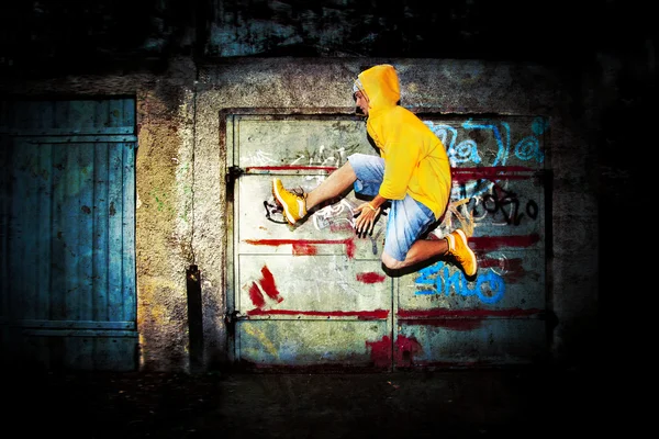Νεαρός άνδρας άλματα στον τοίχο grunge — Φωτογραφία Αρχείου