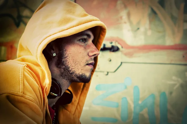 Retrato de hombre joven en la pared grunge graffiti — Foto de Stock