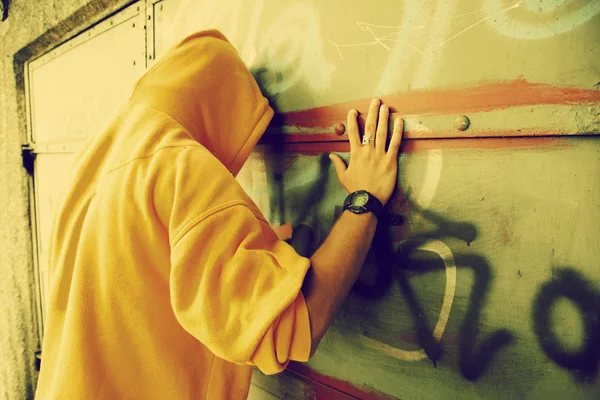 Jovem na parede de graffiti grunge — Fotografia de Stock