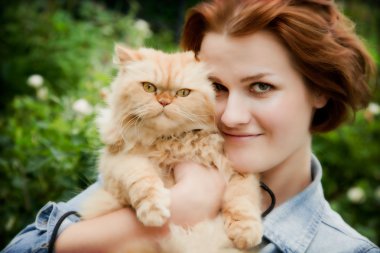 Young woman with Persian cat playing clipart