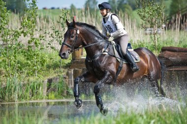 kadın eventer at üzerinde su sıçrama koşmak