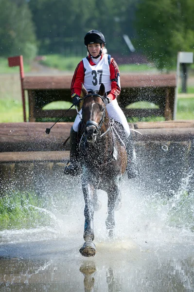 Mulher eventer no cavalo é executado em salto de água — Fotografia de Stock