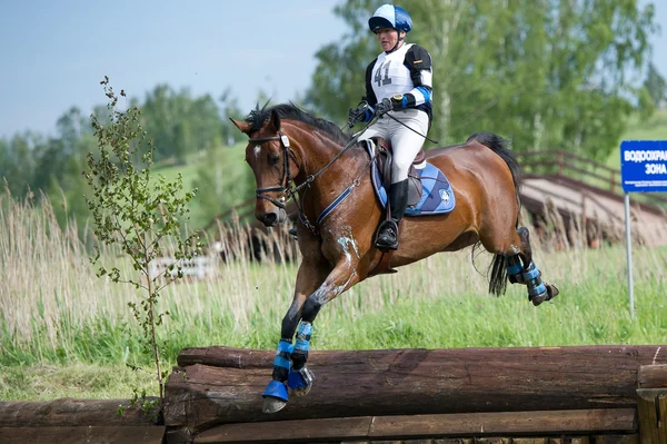 Woman eventer on horse is Drop fence in Water jump — Stock Photo, Image