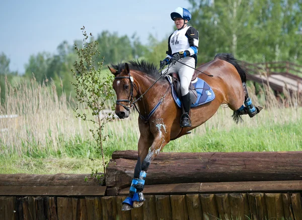 Woman eventer on horse is Drop fence in Water jump — Stock Photo, Image