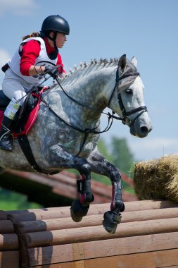 Woman eventer on horse is overcomes the Rolltop clipart