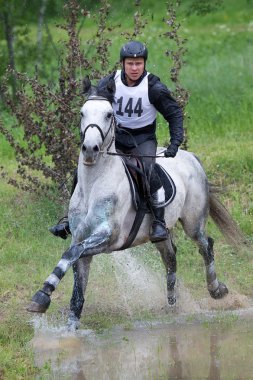 Eventer on horse is overcomes the Water jump clipart