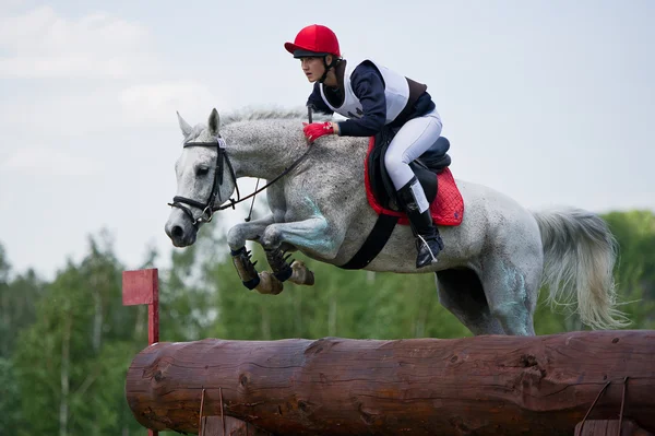 Woman eventer on horse is overcomes the Log fence — Stock Photo, Image