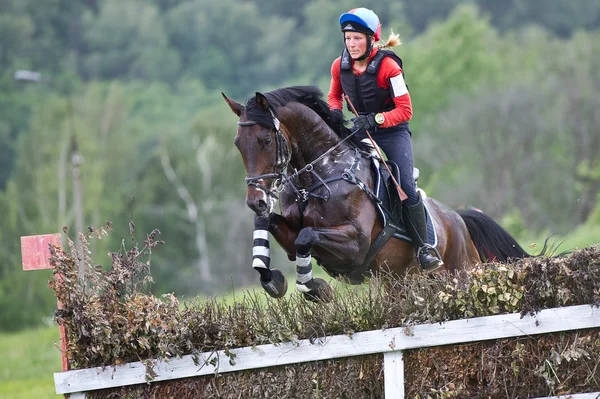 Vrouw eventer op paard is overwint het hek — Stockfoto