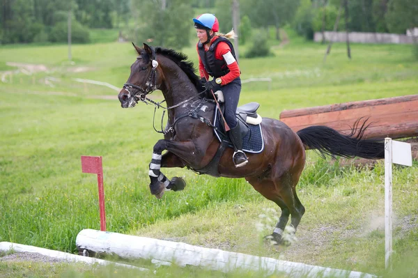 Mulher eventer no cavalo é supera a vala aberta — Fotografia de Stock
