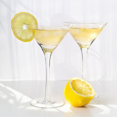 Martini alcohol cocktail with yellow lemon on white clipart