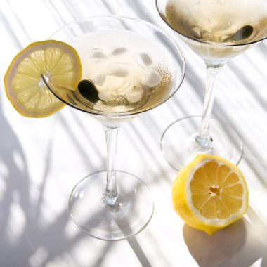 Top view of martini alcohol cocktail with yellow lemon on white with shadows clipart