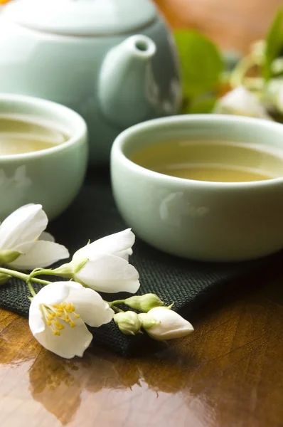 Tè verde con gelsomino in tazza e teiera sul tavolo di legno — Foto Stock