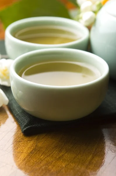 Chá verde com jasmim na xícara e bule na mesa de madeira — Fotografia de Stock