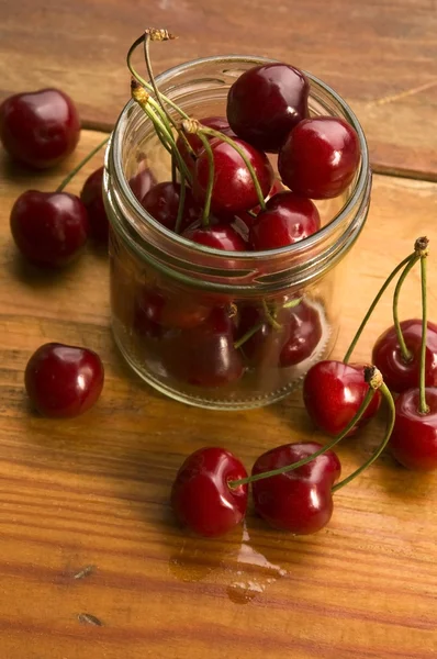 Cherry v sklenice izolovaných na dřevěné pozadí — Stock fotografie