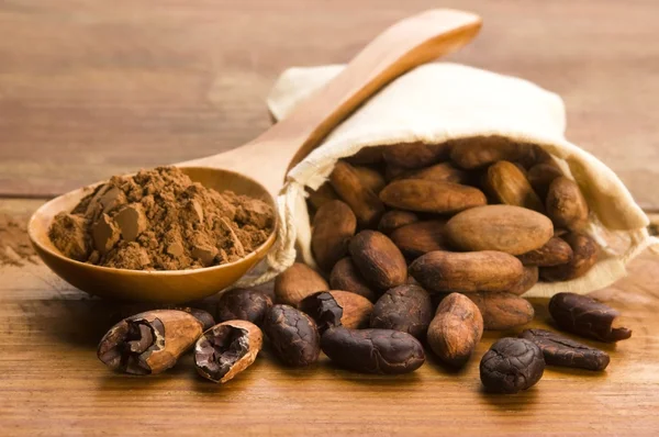 Kakao (kakao) fazole na přírodní dřevěný stůl — Stock fotografie