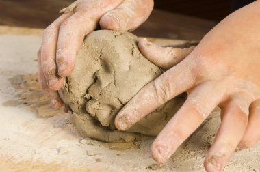 Child hands of a potter clipart