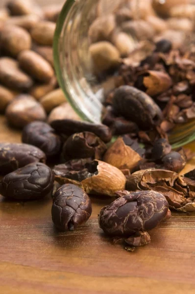 stock image Cocoa (cacao) beans on natural wooden table