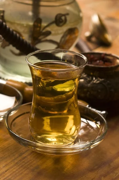 stock image Cup of turkish tea and hookah served in traditional style