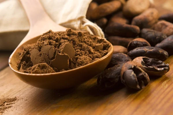 Kakao- (Kakao-) Bohnen auf natürlichem Holztisch — Stockfoto