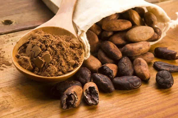 Kakao- (Kakao-) Bohnen auf natürlichem Holztisch — Stockfoto