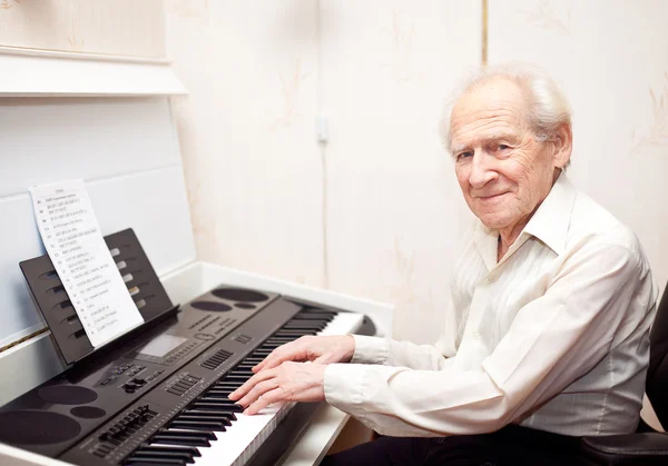 Zadowolony człowiek starszy gry na fortepianie — Zdjęcie stockowe