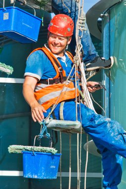 A man cleaning windows on a high rise building clipart