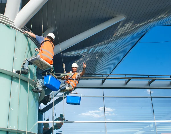 Чоловік прибирає вікна на висотній будівлі — стокове фото