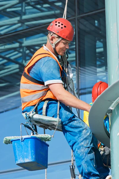 एक माणूस उच्च उंची इमारतीवर खिडक्या स्वच्छता — स्टॉक फोटो, इमेज