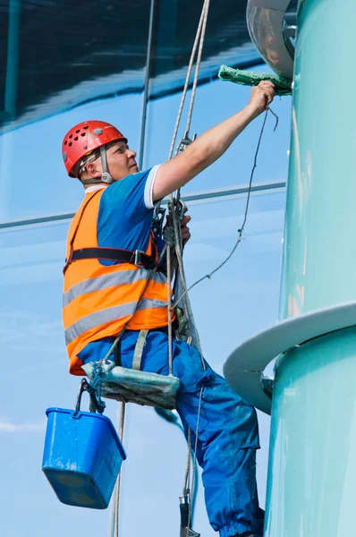 Stock image A man cleaning windows on a high rise building