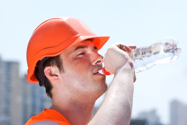 Konstruktor pracownika w mundurze i hełm z butelka wody — Zdjęcie stockowe
