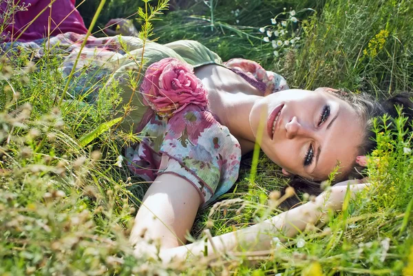 Милая молодая женщина лежит на травяном поле в парке — стоковое фото
