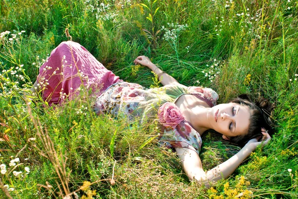 Ładny młoda kobieta leżący na boisko w parku — Zdjęcie stockowe