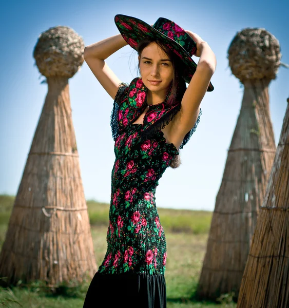 Young woman in stylish hat walking in the park. Ethnic style. — Stock Photo, Image