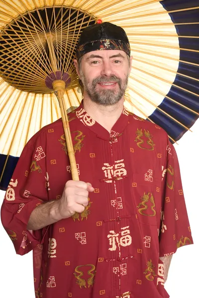 Man in Chinese dress holding an umbrella — Stock Photo, Image