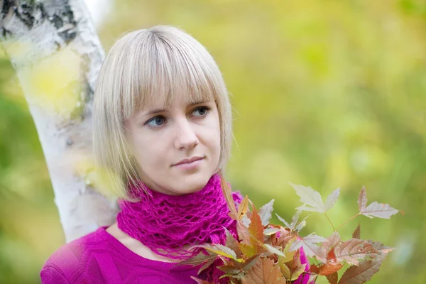 Mooie blonde bij fall gebladerte — Stockfoto