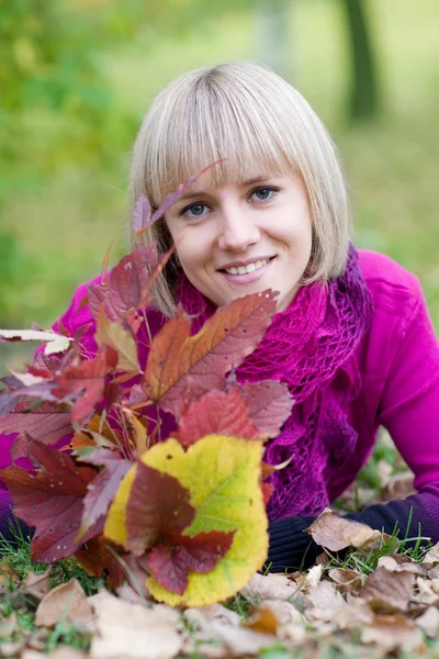 Chica acostada en hojas de otoño — Foto de Stock