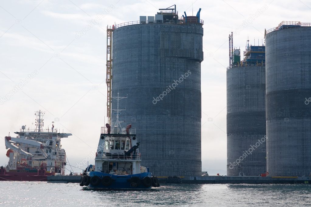 Base of oil platform and tugs