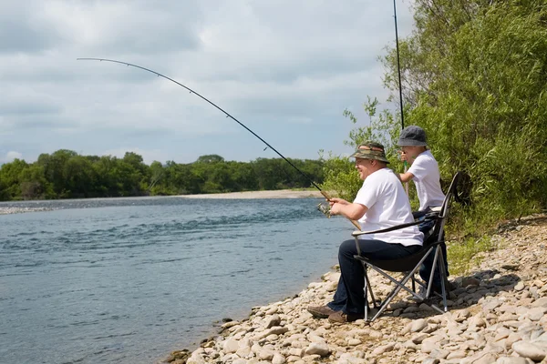Дедушка и внук идут на рыбалку. — стоковое фото