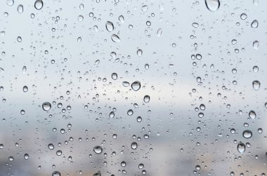 Yağmur damlaları cama düşer