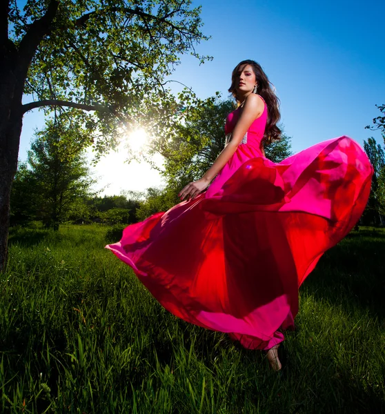 Женщина в длинном розовом платье — стоковое фото