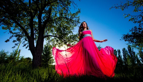 Žena v dlouhé růžové šaty — Stock fotografie