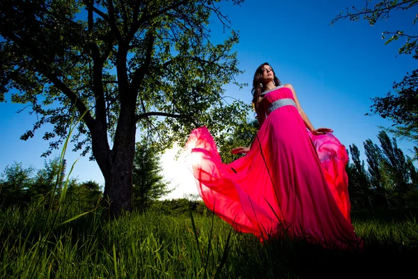 Mulher em um vestido rosa longo — Fotografia de Stock