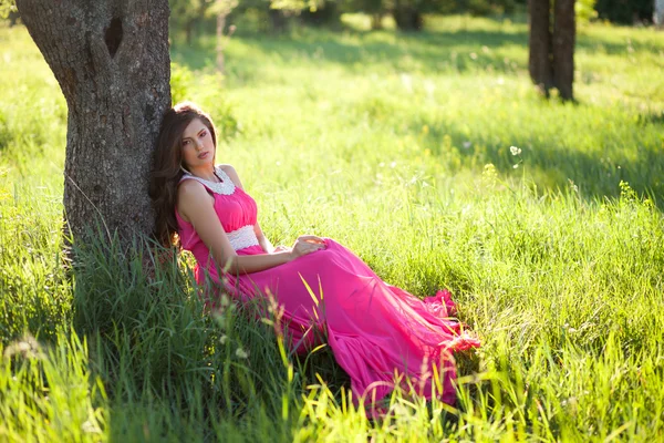 Женщина в длинном розовом платье — стоковое фото